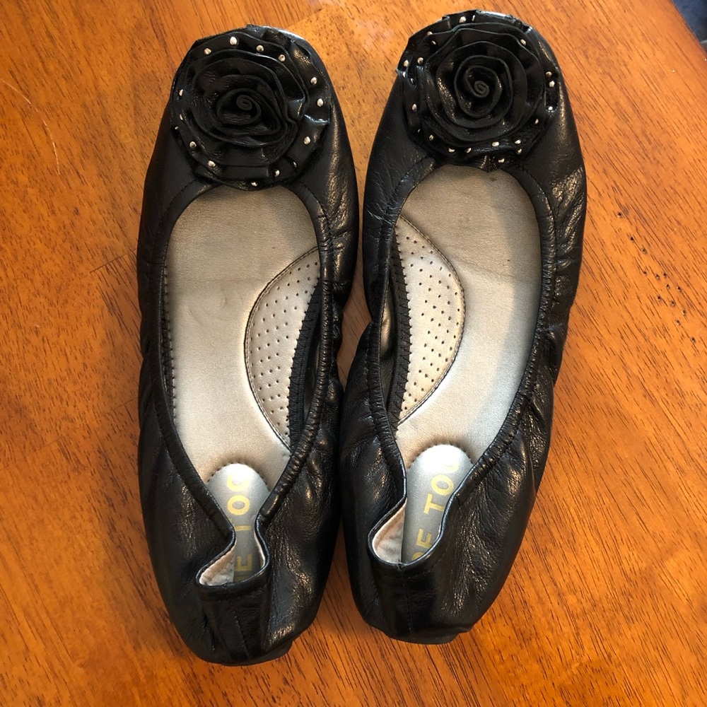 Black leather flats with floral studded toe